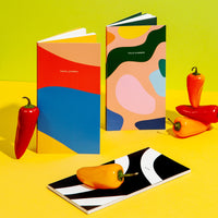 The PK Folio Notebook displayed with other notebooks in a kitchen setting.