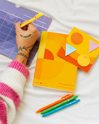 a hand with Poketo x Headspace products on a white background