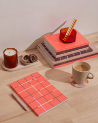 Object Notebook in Tangerine in a desk setting.