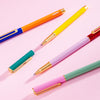 The PK Colorblock Cap Pens displayed on a pink background.