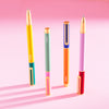 The PK Colorblock Cap Pens Set of 4 on a pink background.