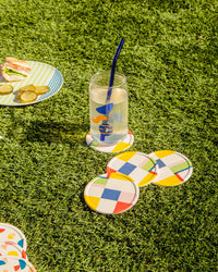 Bamboo coasters and drinking glass with glass straw and a plate