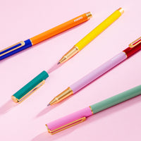 The PK Colorblock Cap Pens displayed on a pink background. 