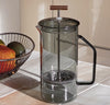 A Gray Glass French Press on a cream kitchen counter.