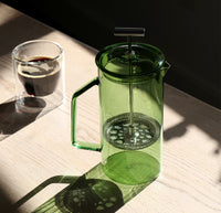 A Verde Glass French Press with a clear Double Wall Glass behind it. 