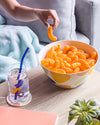 Bamboo serving bowl and glass cup with cheetos